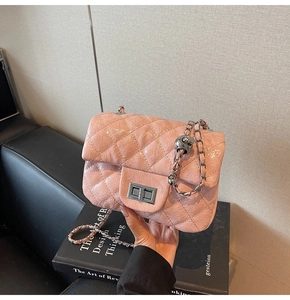 Détail du petit sac rose poudré avec matelassage en losanges et fermoir rotatif argenté