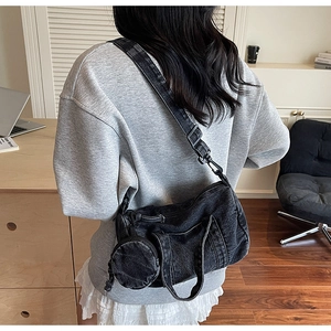 Detail of black washed denim crossbody bag with detachable round coin purse and wide strap