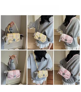 Borsa a tracolla a quadretti con dettagli in perle e fiocco in pizzo su una modella