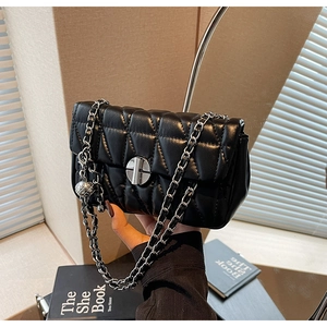 Detail of classic black quilted leather shoulder bag with silver chain strap and twist lock