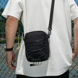 Detail of waterproof nylon crossbody bag with adjustable elastic drawstring and matte finish