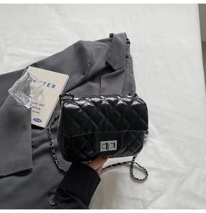 Vue détaillée du sac à bandoulière matelassé noir avec fermoir rotatif argenté