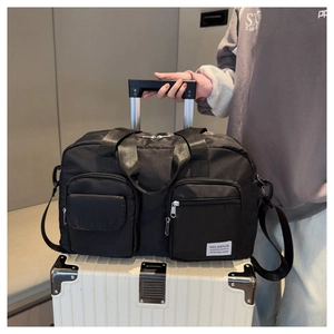 Detail of black travel bag with trolley sleeve attached to a white suitcase handle