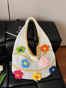 Sac fourre-tout en tricot blanc avec fleurs 3D colorées sur canapé en cuir noir