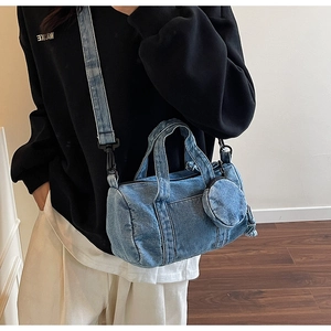 Dettaglio della borsa a cilindro in denim lavato con mini portamonete tondo appeso