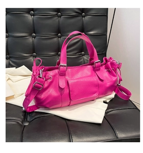 Detail of fuchsia litchi pattern leather handbag with silver buckles and drawstring