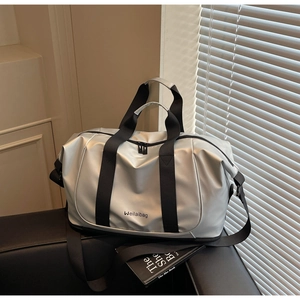 Close-up of silver metallic travel bag with black nylon straps and metal zippers