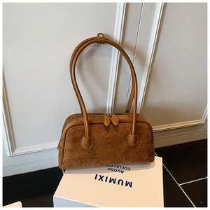Detail of caramel brown suede baguette bag with dual zipper and double shoulder straps