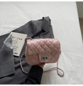 Sac rose matelassé à chaîne avec fermoir argenté présenté sur un blazer gris élégant