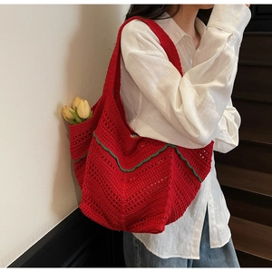 Detail of red handmade crochet tote bag with green trim and hollow wave knit pattern