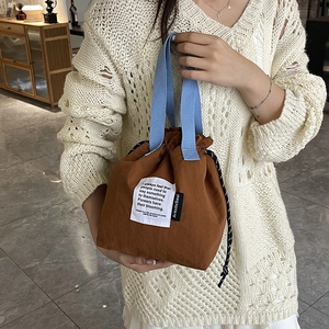 Brown canvas lunch bag with blue handles and drawstring closure for daily commuting