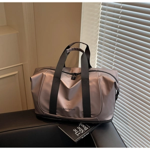 Close-up of the expandable champagne travel bag with durable straps and brand logo
