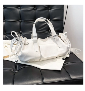 Close-up of white lychee leather handbag with silver buckles and side drawstring detail