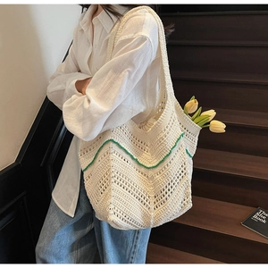Detail of crochet knit tote bag with green wavy lines and floral interior detail