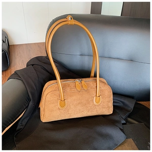 Detailed view of brown suede bag with caramel leather straps and white contrast stitching
