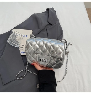 Détail du sac matelassé argenté avec finition métallique et chaîne à boule réglable