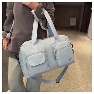 Close-up of a blue waterproof travel bag featuring front pockets and adjustable straps