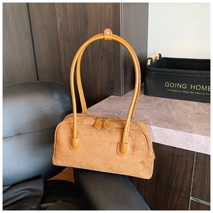 Detail of brown suede baguette bag featuring double zippers and reinforced top handles