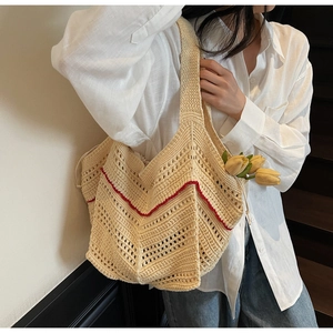 Detail of crochet tote bag with red wave stripes and hollow knit texture on model shoulder