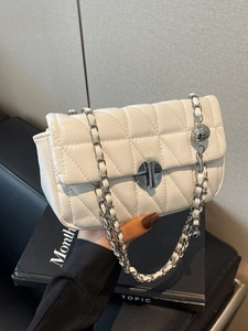 Elegant white quilted leather flap bag with silver chain strap and metallic ball charm