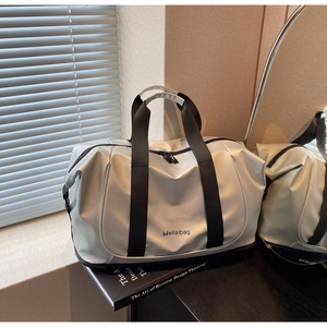 Detail of silver travel bag showing metallic waterproof fabric and black handle texture