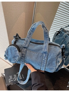 Retro blue denim cylinder bag with shoulder strap and mini coin purse in hand