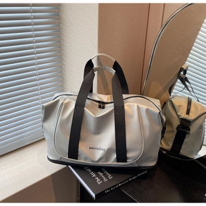 Detail of silver travel bag showing smooth pearlescent texture and durable handles