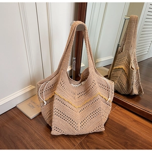 Detail of beige hand-knitted tote bag with yellow trim and white drawstring inner bag