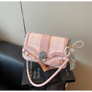 Dettaglio borsa a quadri rosa con bordo in pizzo e decorazione con catena di perle