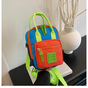 Detailed view of mini nylon crossbody bag with colorful patchwork design and zipper pocket
