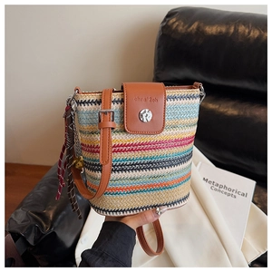 Détail du sac seau en paille multicolore avec bandoulière en cuir et gland coloré