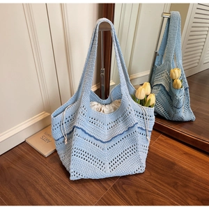 Close-up of light blue crochet knit tote bag with wave textures and drawstring lining
