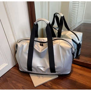 Detail of silver metallic travel bag with durable black nylon straps and water-resistant finish