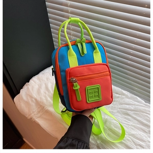 Detail view of colorful nylon mini backpack with vibrant blue, orange, and neon green panels
