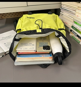 Large capacity neon nylon backpack interior showing laptop, tablet, and essentials