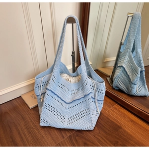 Detail of light blue woven tote bag showing wavy texture and drawstring inner pouch