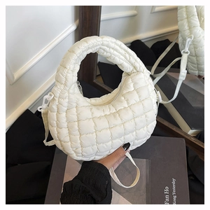 Close-up of pearl white quilted cloud bag with premium nylon texture and handle details