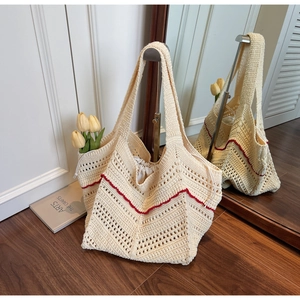 Detail of cream crochet tote bag featuring red wavy patterns and drawstring liner