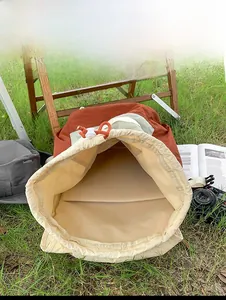 Detail view of the spacious inner compartment and pocket of the rust red nylon backpack