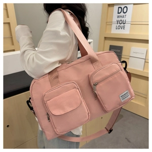 Detail shot of pink travel bag features durable fabric and front zipper pockets