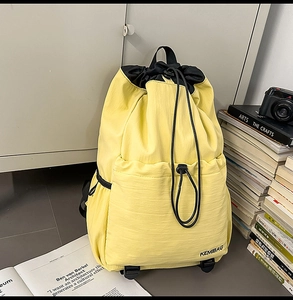 Macro shot of yellow nylon backpack with drawstring closure and front pocket for travel