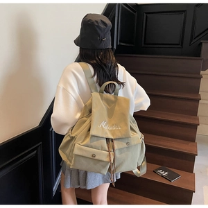 Detail of khaki green canvas backpack with drawstring closure and Mulaidiss embroidery