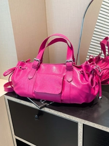 Pink leather shoulder bag with cylinder shape and decorative drawstring detail