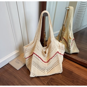 Detail of hollow-out crochet tote bag in cream white with vibrant red wave pattern embroidery