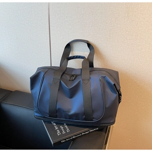 Detail of navy blue waterproof nylon travel bag with bottom shoe compartment and dual handles