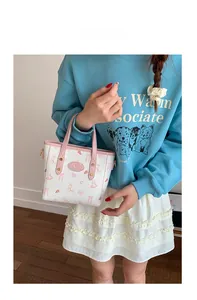 Lifestyle shot of white bucket bag with pink rabbit pattern and handle on model