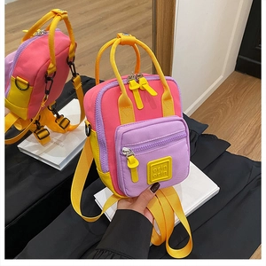 Detail of multi-color mini backpack with pink, purple, and yellow canvas panels