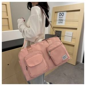Pink large capacity travel bag showing front zipper pockets and durable nylon fabric