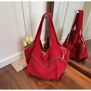 Detail of red hand-woven knit tote bag with green wavy trim and tulip drawstring accent