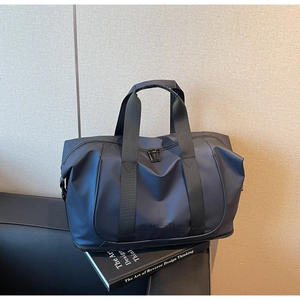 Macro detail of navy blue waterproof travel bag featuring a separate bottom compartment